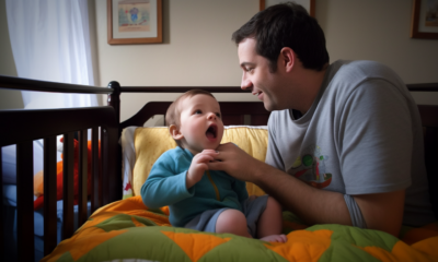 An image of two children happily playing with toys in a daycare center, while a group of dads sit and chat in the background.