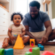 A group of fathers gathered in a brightly lit playroom, surrounded by toys and children of various ages. Some fathers are chatting while others are engaged in play with the kids. It's a scene of joy and bonding as fathers take on the role of caregiver for their children.